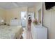 Bright main bedroom with light yellow walls, white furniture, and hardwood floors leading into the bathroom and kitchen at 8402 Princess Ct, Palmetto, FL 34221