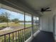 A screened patio featuring black railing, a black ceiling fan, and an outdoor view with a pond at 859 Audubon Dr # 859, Bradenton, FL 34209