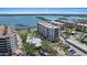 An aerial view of multiple condos, a pool, parking, and access to waterfront views at 8735 Midnight Pass Rd # 306B, Sarasota, FL 34242