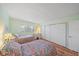 Bright bedroom featuring two beds, hardwood floors, shutters on the window, and a closet at 8735 Midnight Pass Rd # 306B, Sarasota, FL 34242