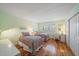Bright bedroom featuring two beds, hardwood floors, shutters on the window, and light green walls at 8735 Midnight Pass Rd # 306B, Sarasota, FL 34242