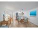 Bright dining area featuring a glass table, rattan chairs, and an open view to the kitchen with modern appliances at 8735 Midnight Pass Rd # 306B, Sarasota, FL 34242