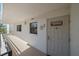 Exterior entrance to a condo featuring a white door, textured walls, and an overhead light at 8735 Midnight Pass Rd # 306B, Sarasota, FL 34242
