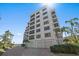 Exterior of building with garage parking, tropical landscaping, and modern design at 8735 Midnight Pass Rd # 306B, Sarasota, FL 34242
