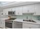 Bright kitchen features white cabinets, stainless appliances, subway tile backsplash and quartz countertops at 8735 Midnight Pass Rd # 306B, Sarasota, FL 34242