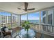 Screened lanai boasting expansive water views, outdoor seating, and a ceiling fan for comfortable relaxation at 8735 Midnight Pass Rd # 306B, Sarasota, FL 34242