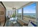 Bright lanai featuring a ceiling fan, tile flooring, an area rug, and floor to ceiling windows with water views at 8735 Midnight Pass Rd # 306B, Sarasota, FL 34242