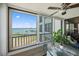 Screened lanai with expansive water views, sliding glass doors, and a ceiling fan for comfortable relaxation at 8735 Midnight Pass Rd # 306B, Sarasota, FL 34242