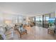 Inviting living room with tile floors, comfortable seating, and sliding glass doors leading to a lanai with serene water views at 8735 Midnight Pass Rd # 306B, Sarasota, FL 34242