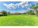 Lush green backyard with a black metal fence and manicured landscaping at 10015 Marbella Dr, Bradenton, FL 34211