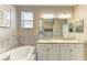 Bathroom featuring double vanity, soaking tub, and granite countertops at 10015 Marbella Dr, Bradenton, FL 34211