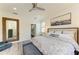 Comfortable main bedroom with ensuite bath featuring a ceiling fan and large mirror at 10015 Marbella Dr, Bradenton, FL 34211