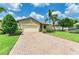 Lovely home with a brick driveway, mature trees, and manicured bushes at 10015 Marbella Dr, Bradenton, FL 34211