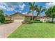 Inviting home with lush landscaping, a brick driveway, and a well-maintained front lawn at 10015 Marbella Dr, Bradenton, FL 34211