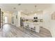 Bright kitchen features white cabinets, granite countertops, stainless steel appliances, and an island with seating at 10015 Marbella Dr, Bradenton, FL 34211