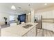 Granite counter island with stainless steel appliances and white cabinets, next to dining area with elegant decor at 10015 Marbella Dr, Bradenton, FL 34211