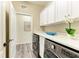 Convenient laundry room with modern washer and dryer and white cabinets at 10015 Marbella Dr, Bradenton, FL 34211