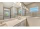 Elegant bathroom with dual sinks, quartz counters, glass-enclosed tiled shower and large mirror at 10054 Cross River Trl, Parrish, FL 34219