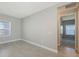 Neutral-toned bedroom featuring tile flooring, window, and door to the hallway at 10054 Cross River Trl, Parrish, FL 34219