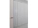 Close-up of white bifold closet doors with white trim and hardware at 10054 Cross River Trl, Parrish, FL 34219