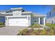 Charming single story home with a two-car garage, light green siding and manicured landscaping at 10054 Cross River Trl, Parrish, FL 34219