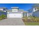 Charming exterior showcasing a two-car garage, stone driveway, and nicely landscaped front yard of this new home at 10054 Cross River Trl, Parrish, FL 34219