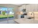 Modern kitchen with a view to the backyard, stainless steel appliances, and white cabinets at 10054 Cross River Trl, Parrish, FL 34219