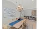 Light and airy dining room with table, seating for six, chandelier and large painting at 11716 Strandhill Ct, Lakewood Ranch, FL 34202