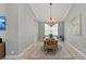 Dining room with decorative chandelier, natural wood table, and light, neutral walls at 11716 Strandhill Ct, Lakewood Ranch, FL 34202