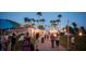 People stroll through an evening market with tents and string lights beneath tall palm trees at 11716 Strandhill Ct, Lakewood Ranch, FL 34202