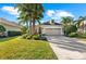 Charming single-story home with a well-manicured lawn, mature palms, and a brick driveway at 11716 Strandhill Ct, Lakewood Ranch, FL 34202