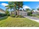 Charming single-story home with a well-manicured lawn, mature palms, and a brick driveway at 11716 Strandhill Ct, Lakewood Ranch, FL 34202