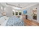 Bright main bedroom with hardwood floors, large windows, ceiling fan, TV, and direct access to the outdoor patio at 11716 Strandhill Ct, Lakewood Ranch, FL 34202