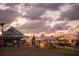 Sunset view of an outdoor market in a Gathering friendly community gathering, filled with tents and community members at 11716 Strandhill Ct, Lakewood Ranch, FL 34202