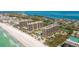 Aerial view of oceanfront condos featuring a pristine beach, lush landscaping, a pool, and other amenities at 1211 Gulf Of Mexico Dr # 309, Longboat Key, FL 34228