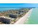A stunning aerial view shows the condo community along the shoreline of a clear blue ocean at 1211 Gulf Of Mexico Dr # 309, Longboat Key, FL 34228