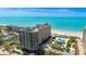 Stunning aerial view of a beachfront condominium complex with a pool and private beach access at 1211 Gulf Of Mexico Dr # 309, Longboat Key, FL 34228