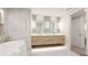 Bright bathroom with marble wall, soaking tub, double sink with floating wood vanity at 1211 Gulf Of Mexico Dr # 309, Longboat Key, FL 34228