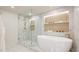 Modern bathroom features marble flooring, soaking tub, glass shower, and accent lighting at 1211 Gulf Of Mexico Dr # 309, Longboat Key, FL 34228
