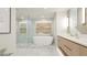 Modern bathroom features marble flooring, soaking tub, glass shower, and floating wood vanity at 1211 Gulf Of Mexico Dr # 309, Longboat Key, FL 34228