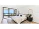 Bright bedroom with ocean view balcony, light wood floors, soft gray rug, and modern decor at 1211 Gulf Of Mexico Dr # 309, Longboat Key, FL 34228