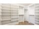 A walk-in closet with adjustable white shelves, drawers and hanging rods at 1211 Gulf Of Mexico Dr # 309, Longboat Key, FL 34228