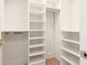 A walk-in closet with adjustable white shelves and hanging rods at 1211 Gulf Of Mexico Dr # 309, Longboat Key, FL 34228