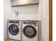 Well-equipped laundry area with front-load washer and dryer and modern marble backsplash and white towels at 1211 Gulf Of Mexico Dr # 309, Longboat Key, FL 34228