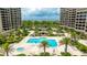 Aerial view of luxurious pool area with palm trees, lounge chairs, and beautifully landscaped grounds at 1211 Gulf Of Mexico Dr # 309, Longboat Key, FL 34228