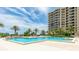 Resort-style swimming pool surrounded by palm trees, sun loungers, and lush landscaping at 1211 Gulf Of Mexico Dr # 309, Longboat Key, FL 34228
