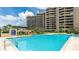 Bright condo complex pool with inviting blue water, palm trees and plenty of seating at 1211 Gulf Of Mexico Dr # 309, Longboat Key, FL 34228