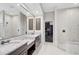 Elegant bathroom with double vanity, granite countertop, walk-in shower, and marble tile at 13 Bayhead Ln, Osprey, FL 34229