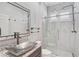 Modern bathroom featuring a marble shower with a glass door and a vessel sink with granite counters at 13 Bayhead Ln, Osprey, FL 34229