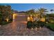 Charming home featuring a paved driveway, manicured landscaping, and exterior lighting at 13 Bayhead Ln, Osprey, FL 34229